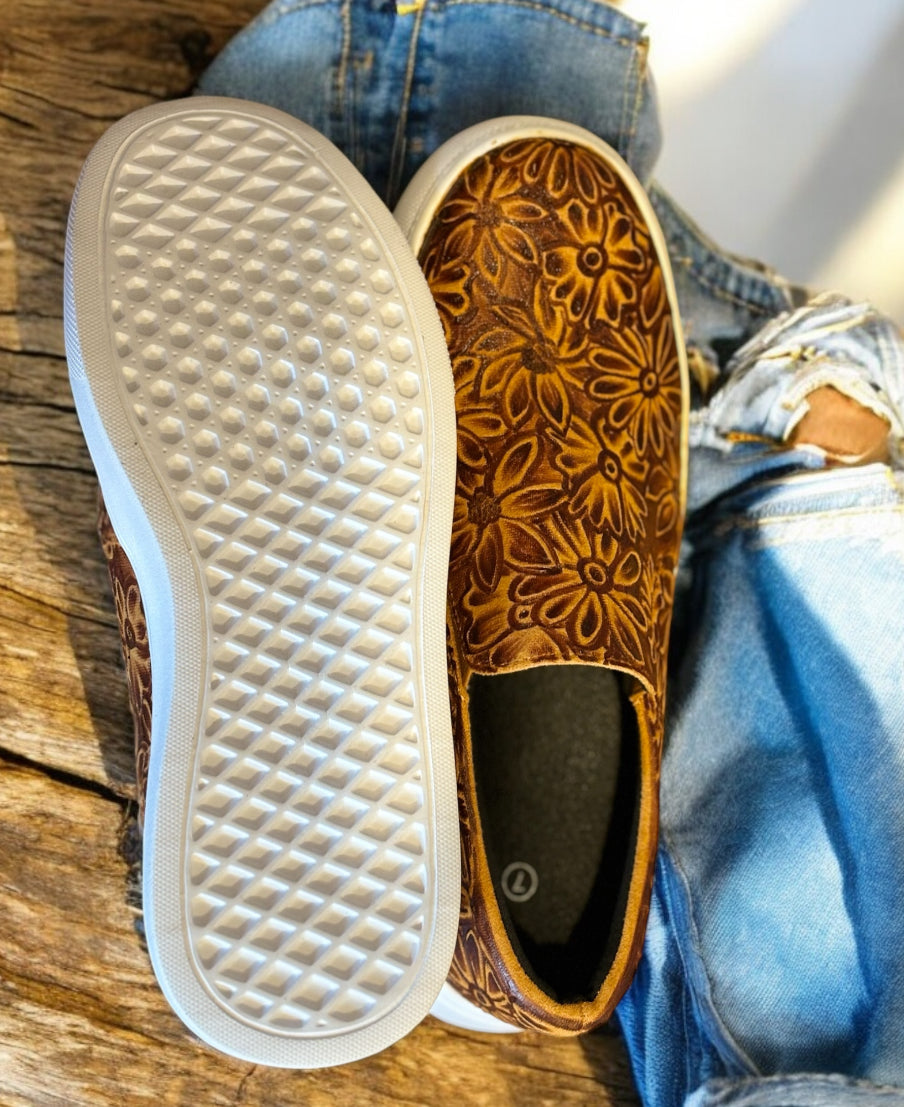 Brown sneakers on a wooden table with jeans.